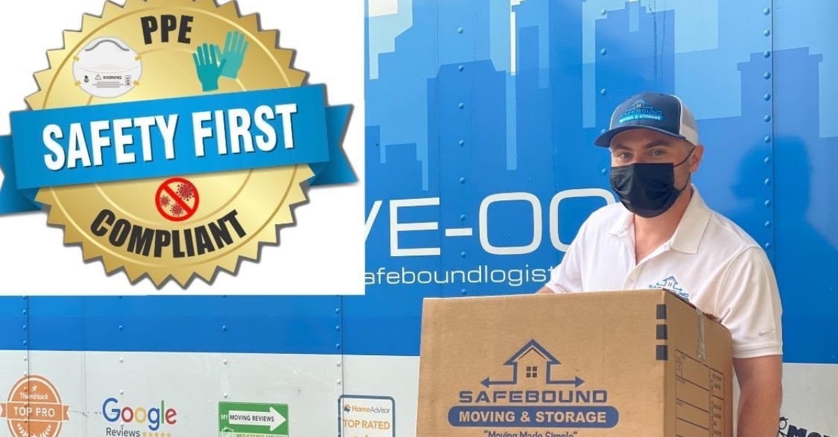 mover holding a box wearing latex gloves and a face mask