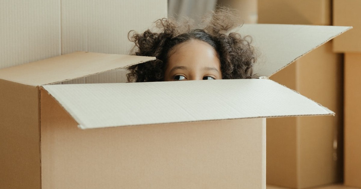 young girl inside cardboard box