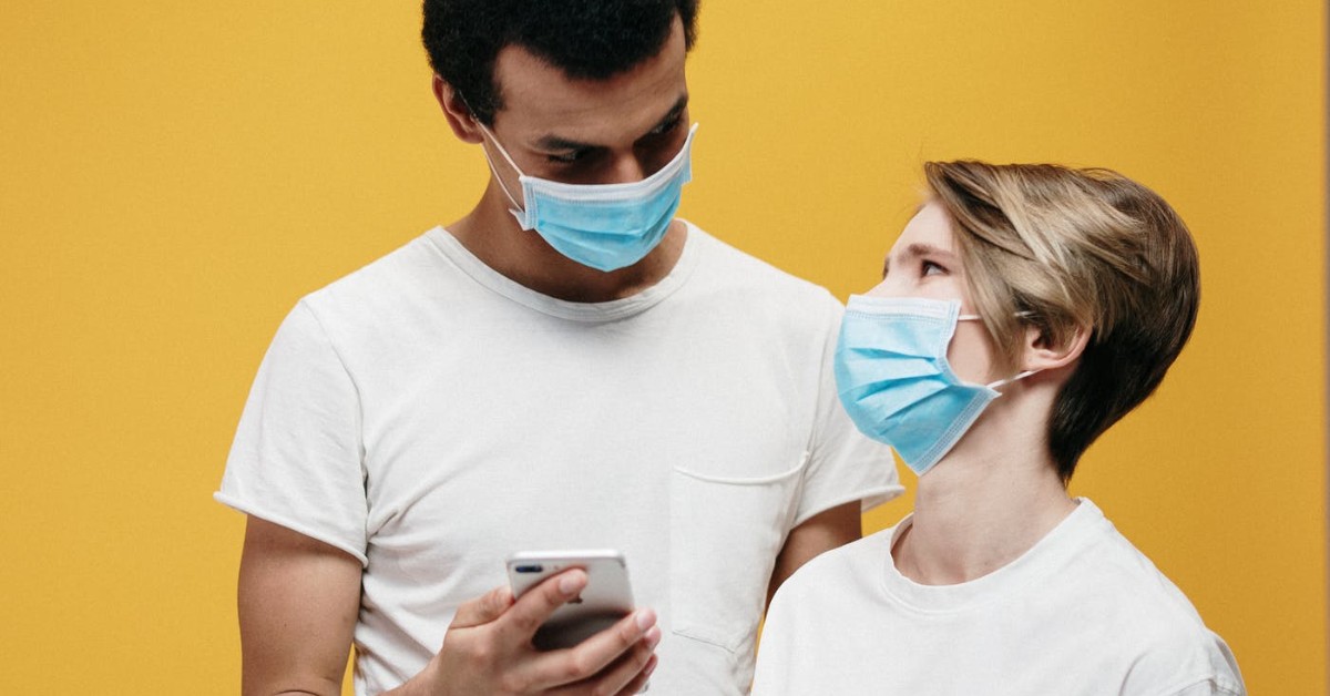 man and woman wearing surgical masks