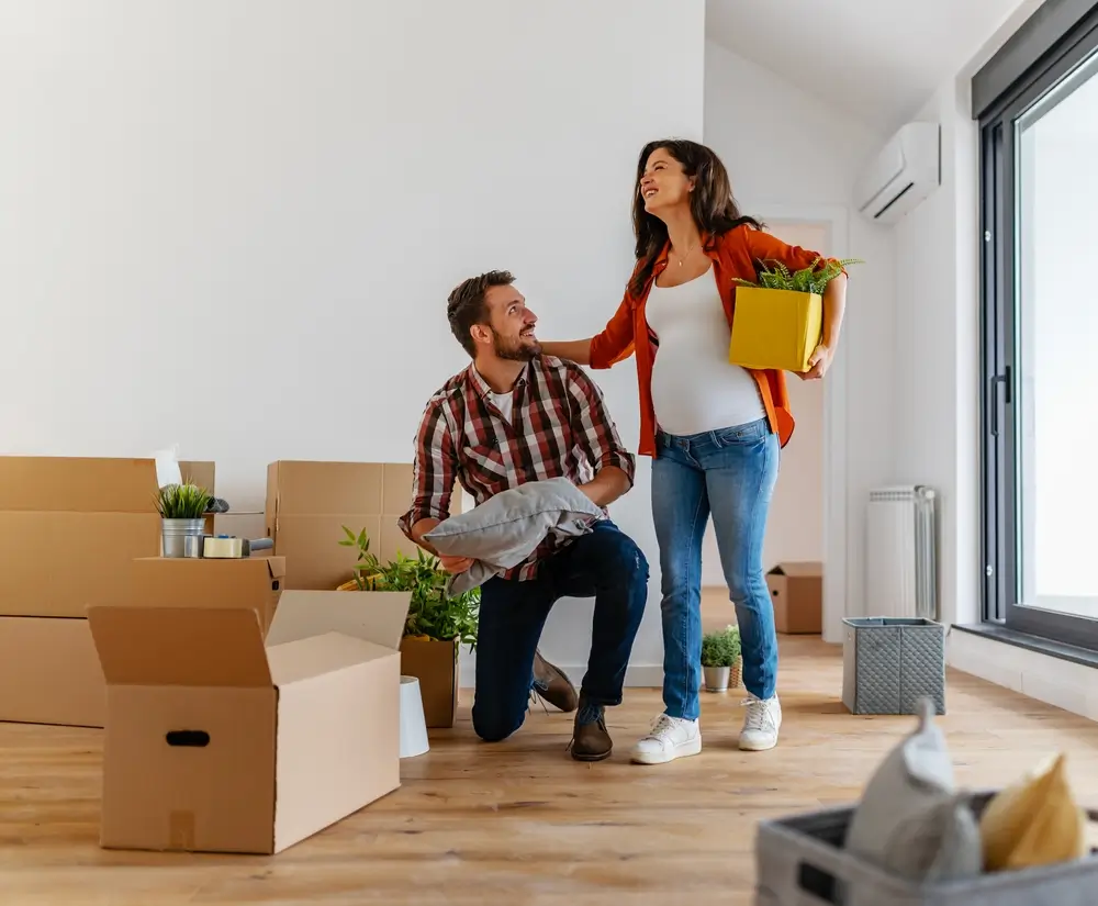 A young couple expecting a baby just moved into an empty apartment unpacking and cleaning.